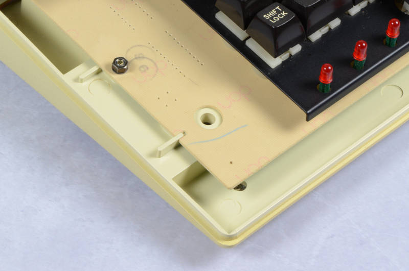 Keyboard is positively located with a small lug on each side (note the yellowing of this case is visible in the groove around the edge)