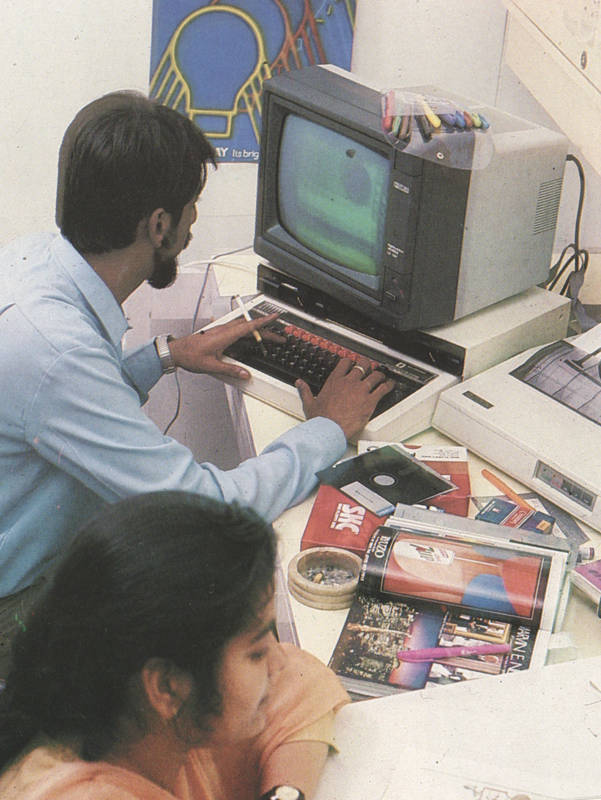 Office environment with disc drives and monochrome monitor — cigarette and ashtray are a sign of the times